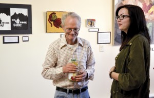 Artists Sam Thurston and Abigail Meredith check out the artwork at the opening of the 99 Gallery Sunday afternoon.  The gallery will also serve as a meeting place for NEK 99%, a grassroots organization for social change.  Photo by Joseph Gresser