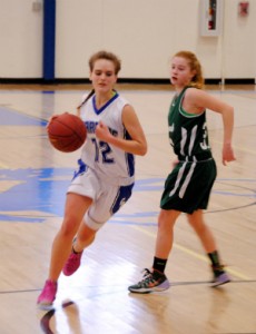 Craftsbury's Meghan Pennock (left) uses some fancy footwork to cut past Whitcomb/Rochester's Lindsey LaPerle during Saturday's DIV quarterfinal in Craftsbury.  A late run enabled the Chargers to finally break through the Hornets' defense and grant the Chargers a 43-35 win to advance to Monday night's semi-finals in Barre. Photo by Richard Creaser