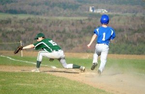 Speedy Craftsbury Charger Caleb Paquette burns down the first baseline and beats out the throw to Whitcomb Hornet Sam Ennis during Friday's varsity baseball game in Craftsbury Common.  Whitcomb would go on to win the game 11-9.
