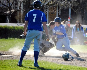 Whitcomb's Alex Messier (center) successfully defends the plate against Craftsbury's Iva Wright during the first inning of the varsity baseball game on Friday night.  Wright's Charger teammate Marc Quirion (foreground) observes after stepping away from the batter's box.  Despite a valiant comeback the Chargers would fall shy and Whitcomb would claim the win 11-9.