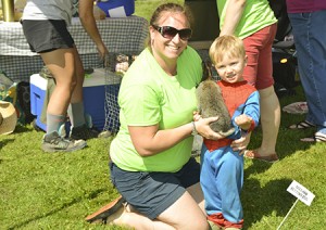Ellen Apple helps her Spiderman suit-clad son Myles hold a bunny at the petting zoo at the block party in Gardener Park in Newport on June 18.  For each animal he held, he asked his mom to go find “Nana” so he could show her.  Photo by Nathalie Gagnon-Joseph