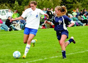 Craftsbury Academy's Aleia Augsburger (left) winds up for a shot.  But United Christian Academy's captain, Moriah Lafoe, (right) steps up to deflect Augsberger's attempt.  Augsberger had three goals.   