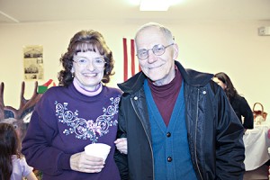 Susan Taylor (left) and Jim Currier come together after a round of Christmas carols Saturday night.
