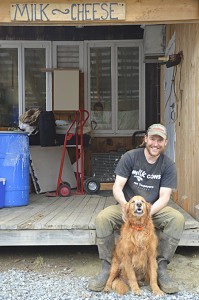 Sweet Rowen Farmstead owner Paul Lisai poses in front of his creamery with his 16-year-old dog, Bailey.