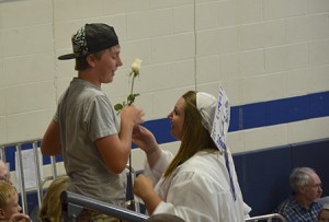 As part of Lake Region Union High School’s graduation ceremony, graduates must give a white rose to someone who has stood by them in their journey.  Pictured here, MaKayla Baraw (right) gives a rose to her brother Hazen Baraw (left).  Photo by Nathalie Gagnon-Joseph