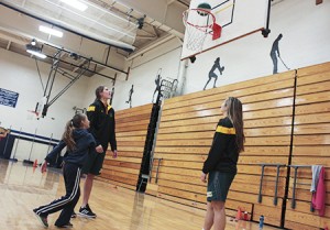 Anya Kennedy shoots a jumper as Gracia Hutson (left) and Kristina White compliment Anya's form.