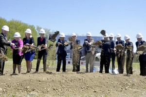 Many of those involved in planning AnC Bio help turn over the first shovels of dirt on May 14.  From left to right, are Vermont State Aeronautics Administrator Guy Rouelle, Jane Fortin and Cindy Robillard of the state Department of Labor, North Country Career Center Director Ilene Illuzzi, Alex Choi, former CEO of AnC Bio Korea, Jerry Davis of PEAK CM, Newport City Mayor Paul Monette, Ariel Quiros, co-owner of Jay Peak Resort and Mr. Stenger’s partner in AnC Bio, Bob Brown Petersen of NME Pharmaplan, AnC Bio Vermont CEO Ike Lee, Jake Lee, who heads development of artificial organs for AnC Bio, and Bill Stenger, president of Jay Peak Resort.  Photo by Joseph Gresser