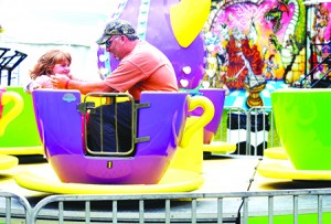 Mike Myers reassures his daughter Abigail as the two spin in a teacup on the midway at the Orleans County Fair in 2014.  The family hails from Winooski, but spends summers at their camp in Sheffield.  Photo by Joseph Gresser