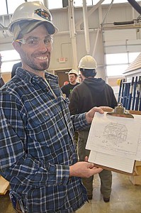 Makaio Maher, who specializes in timber framing, displays the design he found online of Henry David Thoreau’s cabin.  He’s passing some of his expertise on to students from North Country Career Center as they use the design to build a replica of the cabin.