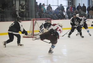 North Country's Adam Viens (center) tips to the side as he rifles a shot a Stowe Raider goalie Dylan Whitaker during Saturday's contest at the Ice Haus in Jay.  Moving in on the play are Raiders J.J. Clark (left) and Luke O'Toole (second from right) and Falcon Ryan O'Donnell. Photo by Richard Creaser