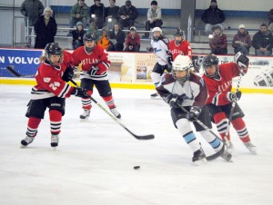 North Country Falcon Whitney Bernier (foreground right) breaks free of a pack of Rutland Red Raiders defenders during Saturday's varsity hockey match up at the Ice Haus in Jay.  Surrounding Bernier are Red Raiders Emily Catellier (left), Mia Steupert, fellow Falcon Cassidy Webster (background center) and Red Raiders Kailie Matteson (background right) and Alicia Williams.  Photo by Richard Creaser