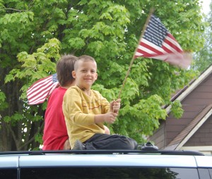 Gage (in yellow) and Joey Prue atop a van in the Memorial Day parade in North Troy Monday.  Pam Prue and Pat Pyne of Paddie’s Snack Bar were their chauffeurs.   Photo by Tena Starr 