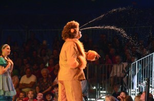 Dorothy (Alyson Mattei), looks sympathetic as the Cowardly Lion (Chase Culp) showers a delighted crowd of children with tears.  