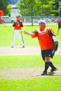 Rhonda Howard, pitching for the Newport-based D&D Electric softball team, delivers a pitch during Sunday's tournament play.  Short stop Ashley Gravel (background left) prepares for the play.   Photo by Richard Creaser
