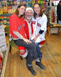 Craftsbury General Store owner Emily Maclure, left, and Michelle Guenard, creator of Michelle’s Spicy Kimchee, pose on Santa’s lap.  Santa was being played by Red Sox baseball player Bill Lee.  Photos by Bethany M. Dunbar