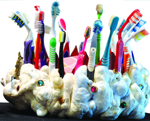 The toothbrush crown is a fashion accessory created by Maryann Colella.  Other newly minted artifacts on display include an alligator with toothbrush teeth crafted by Katherine Nook and a combination cell phone toothbrush, an innovation that, sadly, has yet to catch on.  Photo by Joseph Gresser