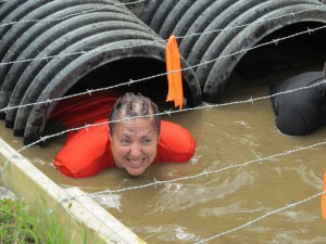Hailey Gentile of Newport Center peeks up after sliding through the Boa Constrictor obstacle during Tough Mudder competition at Mount Snow on Saturday.  She was a member of the Fortitude Fitness Systems team.  For a story and more photos, please turn to page eighteen.  Photo by Lisa Cordeau