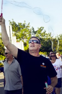Steve Weigl of Syracuse, New York, can march and blow bubbles at the same time.  He kayaked for a competitor in the three-mile swim, held Saturday morning, and joined the Swimmers and Pets Parade on Main Street Friday evening.  Photo by Joseph Gresser